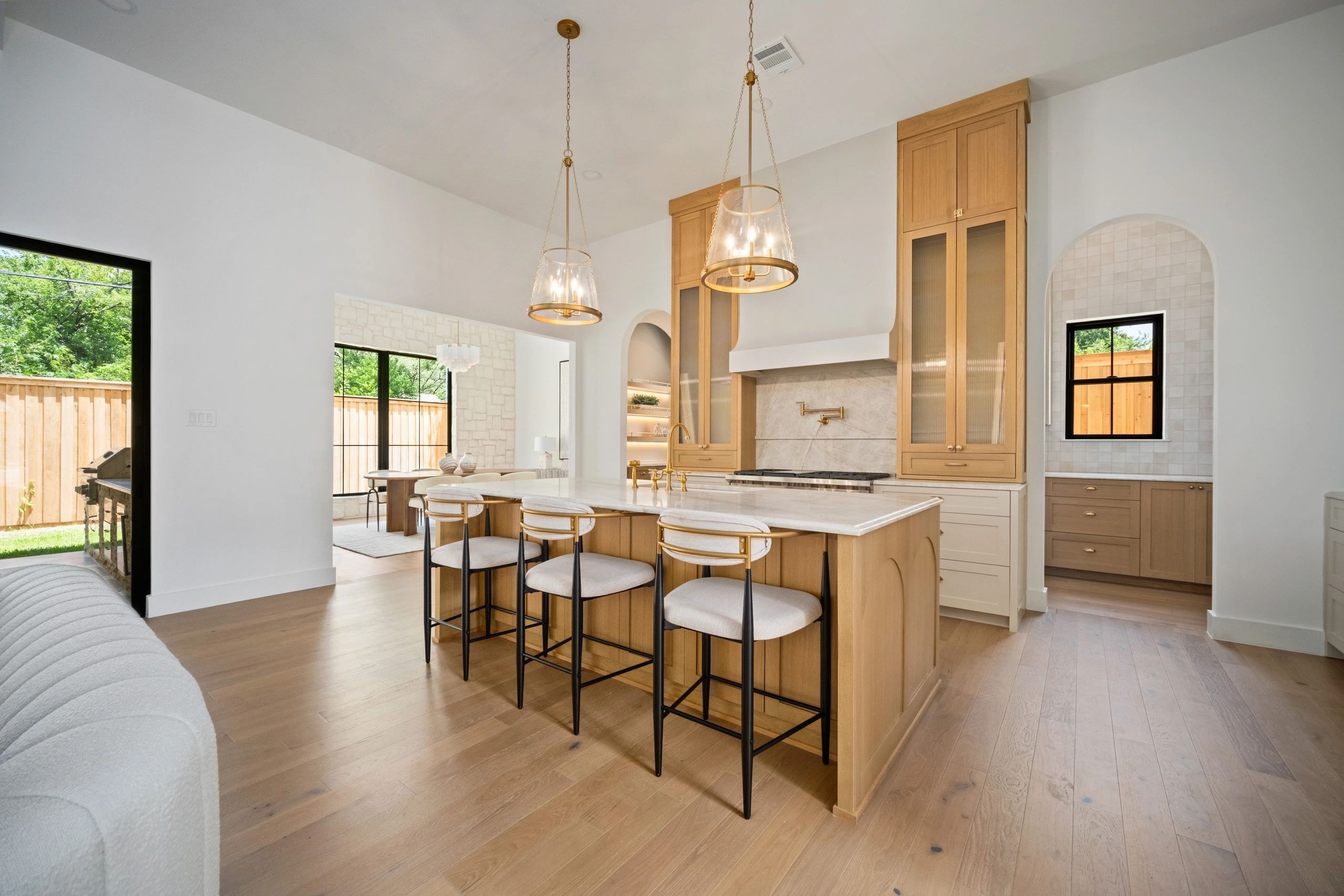 Chef's kitchen with warm wood cabinetry and marble countertops